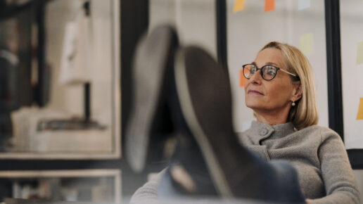 Mature businesswoman in office with feet on desk